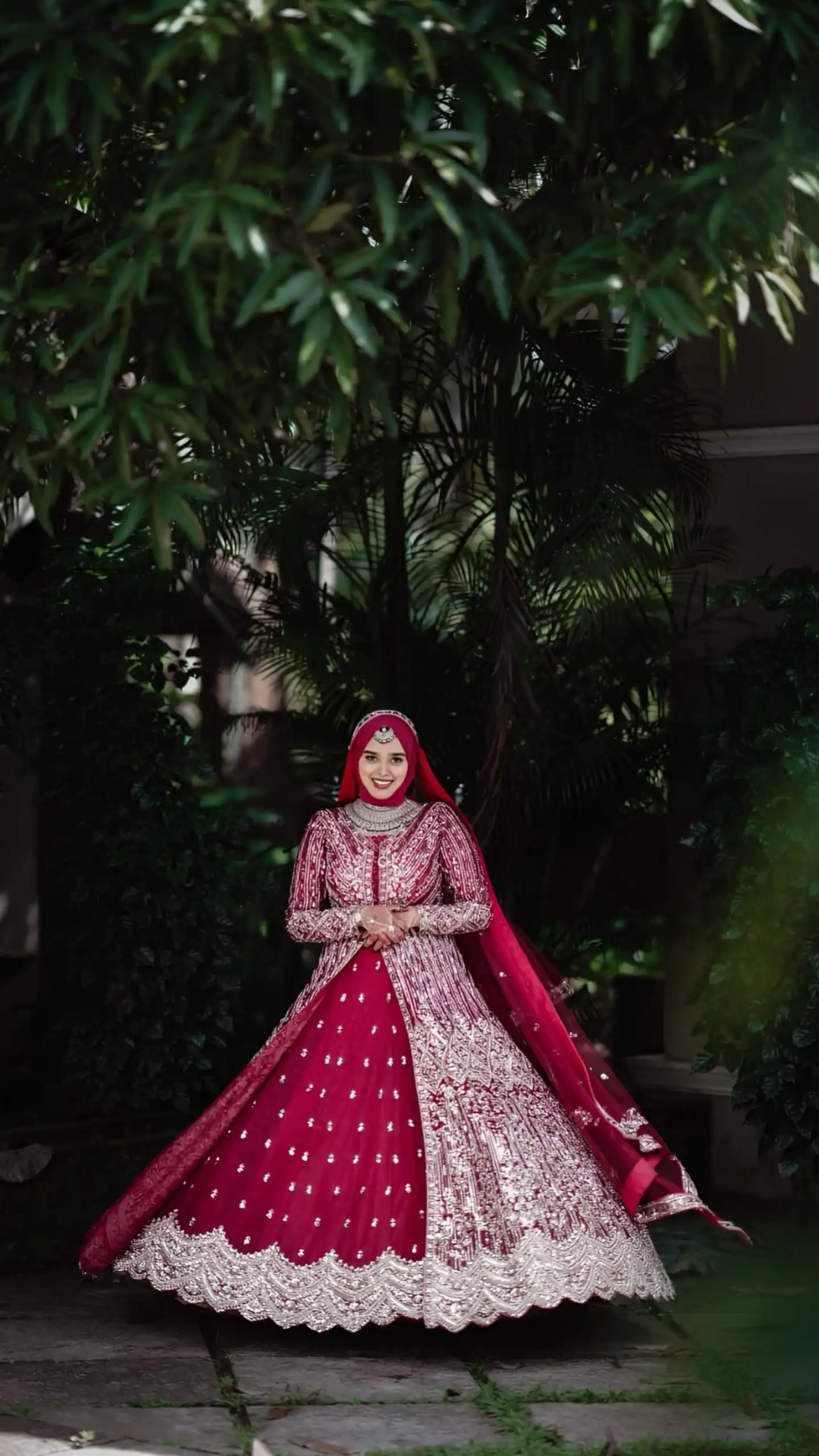 Bride rotating in a red gown on her wedding day, captured by the best wedding photographer in Malappuram